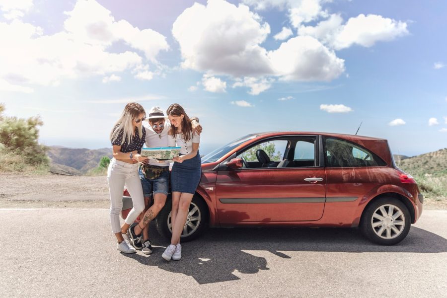 tres-amigos-que-miran-mapa-que-coloca-cerca-coche-moderno-camino_23-2147855608